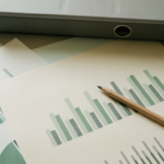 Printed overviews and charts on a desk with a ring binder and a pencil